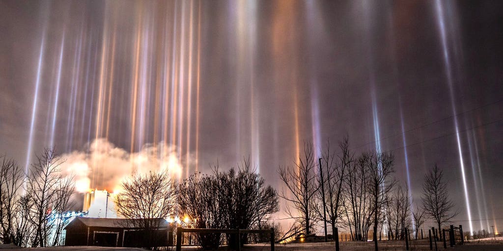 Light pillars illuminate night sky over Canada